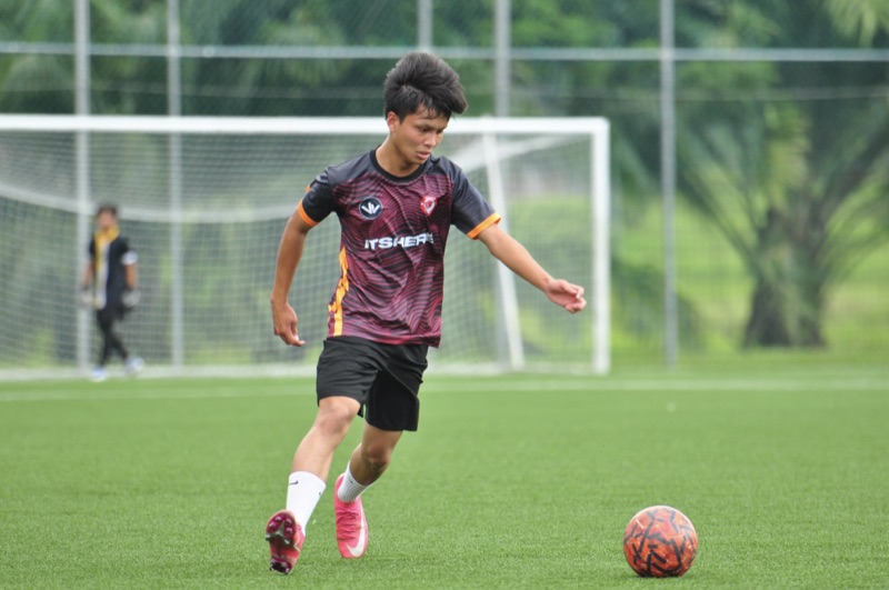 A player running the ball forward in club kit