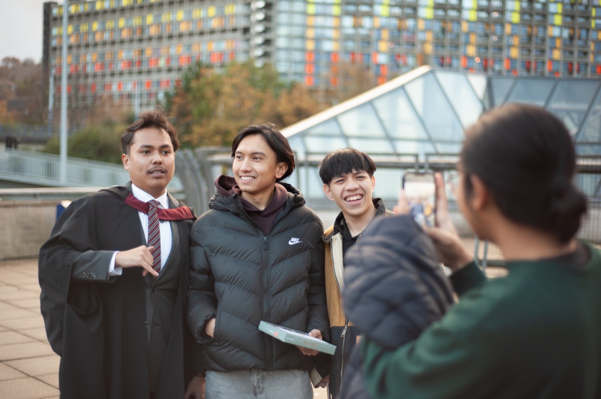 A group of graduates gathered on a campus staircase