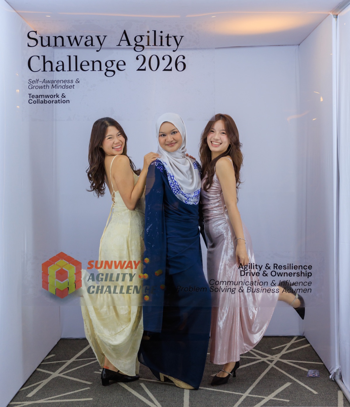 Three guests in evening gowns posing in the booth