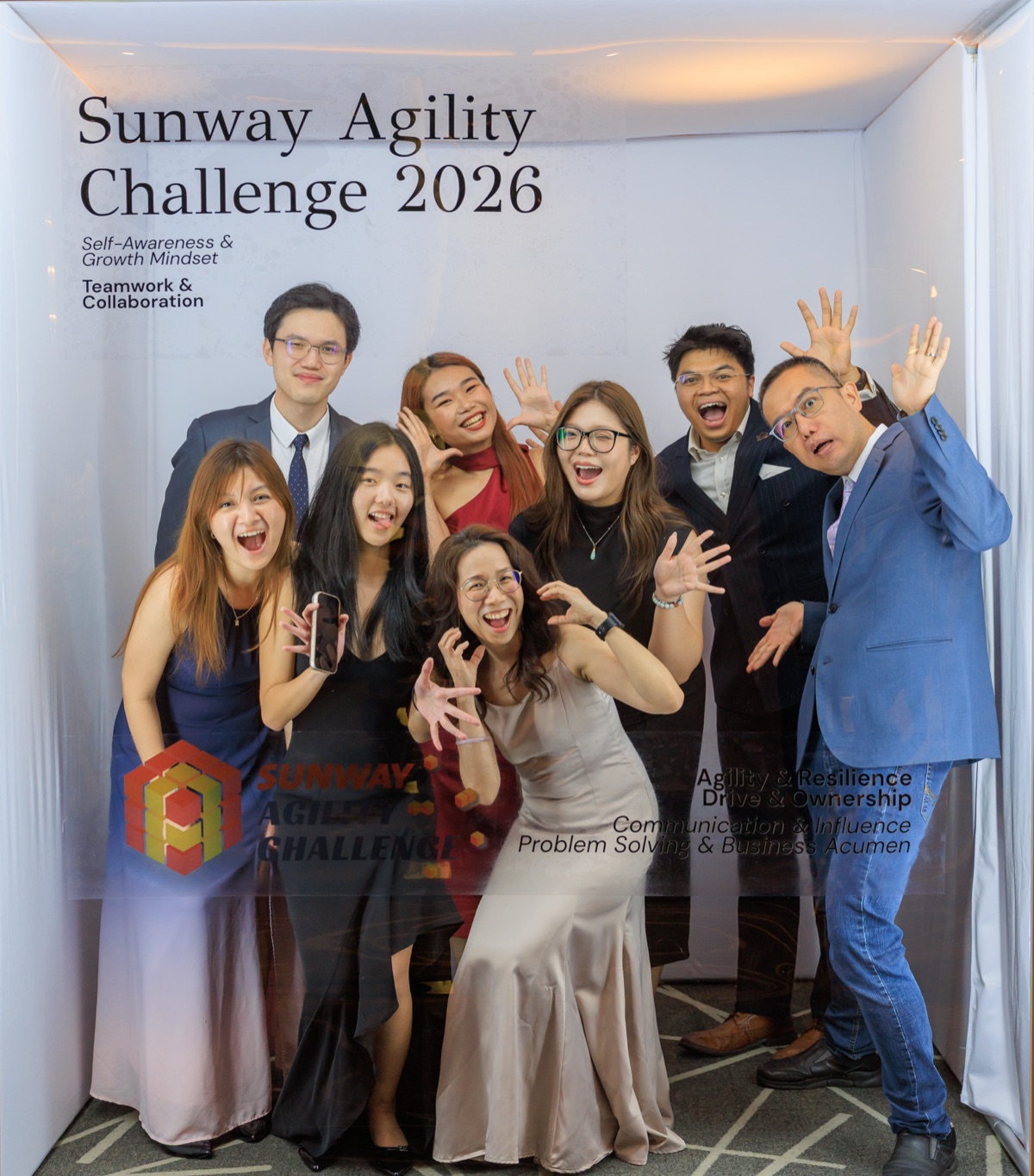 Guests packed into the booth with their arms in the air